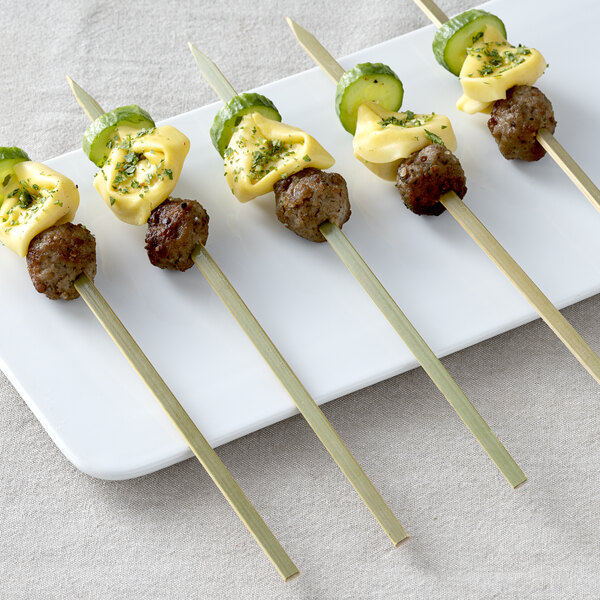 Bamboo skewers with meat and vegetables on a table.