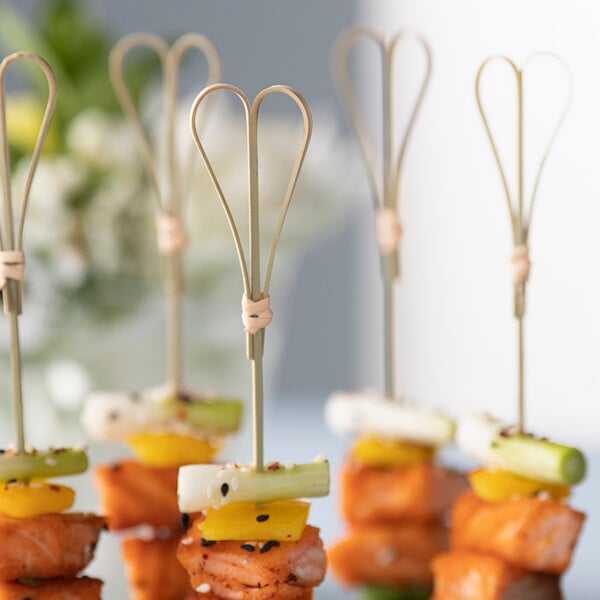 A bunch of Bamboo by EcoChoice heart-shaped bamboo skewers with food on them.