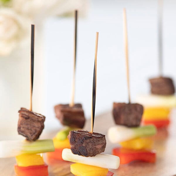 A piece of meat and vegetables on a skewer with a black Bamboo by EcoChoice twisted food pick.