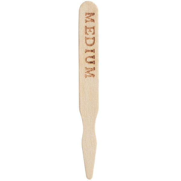 A wooden TreeVive by EcoChoice meat marker with "medium" engraved on it.