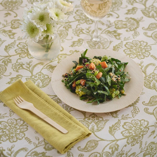 A Bambu Veneerware bamboo plate with a salad and a wooden fork on a table.
