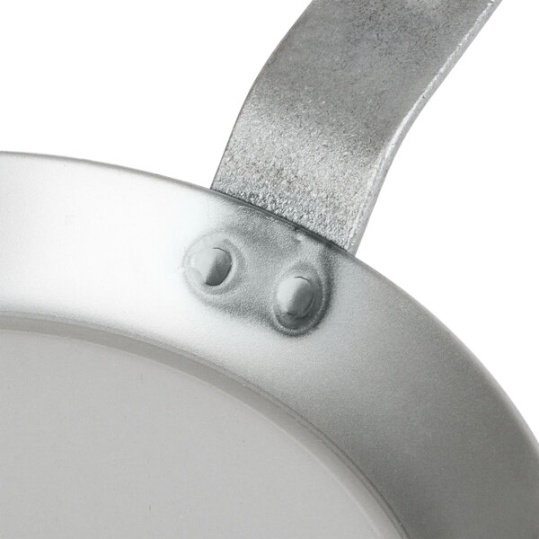 A Matfer Bourgeat black carbon steel crepe pan with a metal handle.