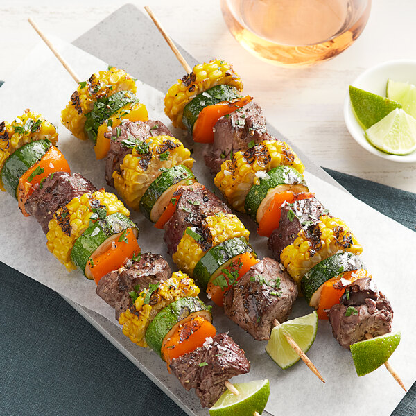 Meat and vegetables on EcoChoice wooden skewers on a white plate.