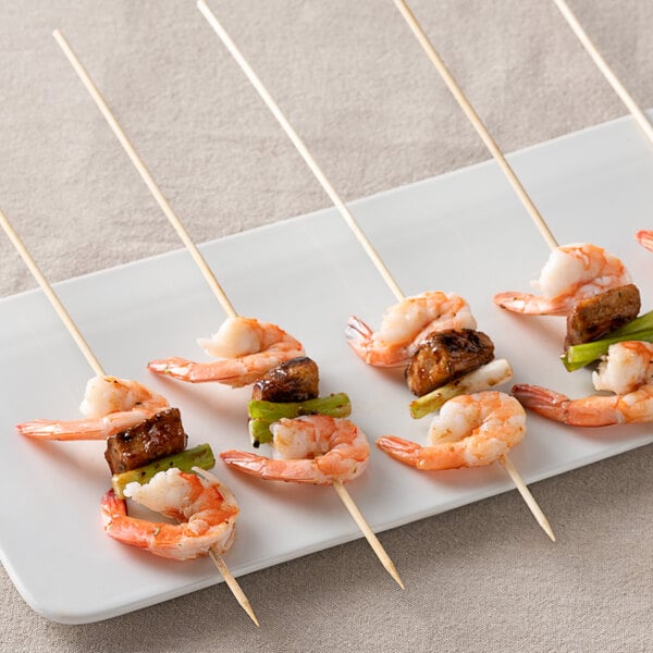 A plate of shrimp skewers with green peppers and mushrooms.