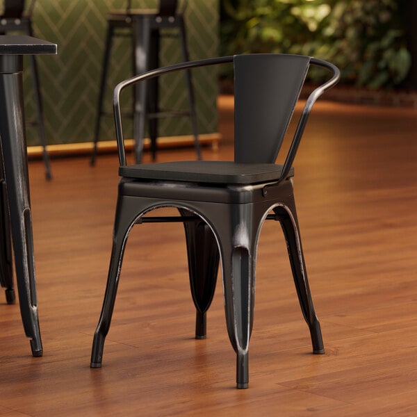 A Lancaster Table & Seating black metal arm chair with a black wood seat.