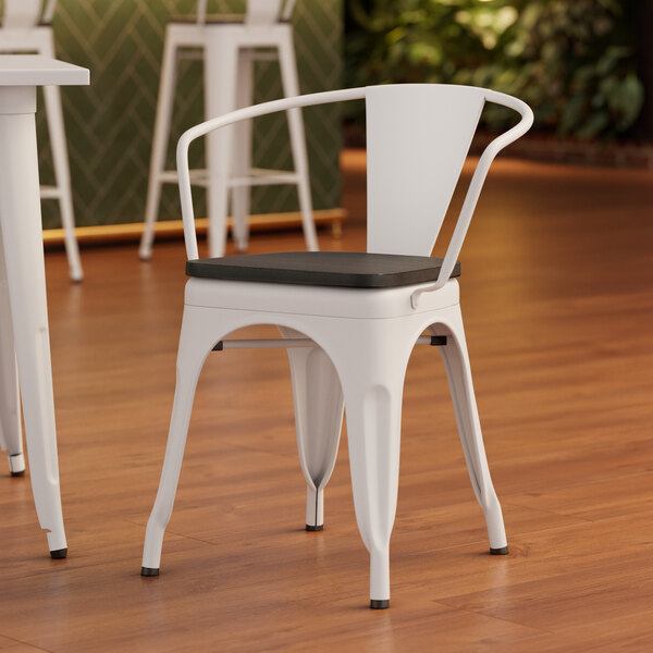A white Lancaster Table & Seating arm chair with a black wood seat.