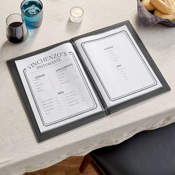 An American Metalcraft black faux leather menu holder on a table with a menu.