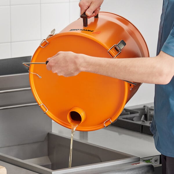 A man pouring oil into an orange Fryclone Smart Pail.