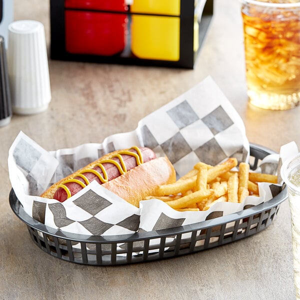 A black checkered basket liner or deli sandwich wrap paper used to serve a hot dog and fries in a plastic basket.