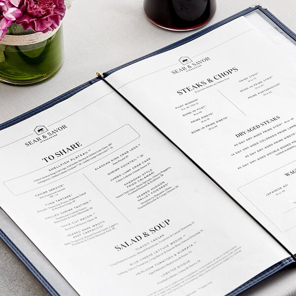 A black H. Risch, Inc. elastic menu band on a menu on a table with flowers and a glass.