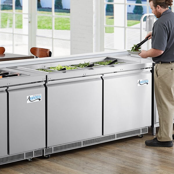 An Avantco stainless steel refrigerated salad bar on a counter in a kitchen.