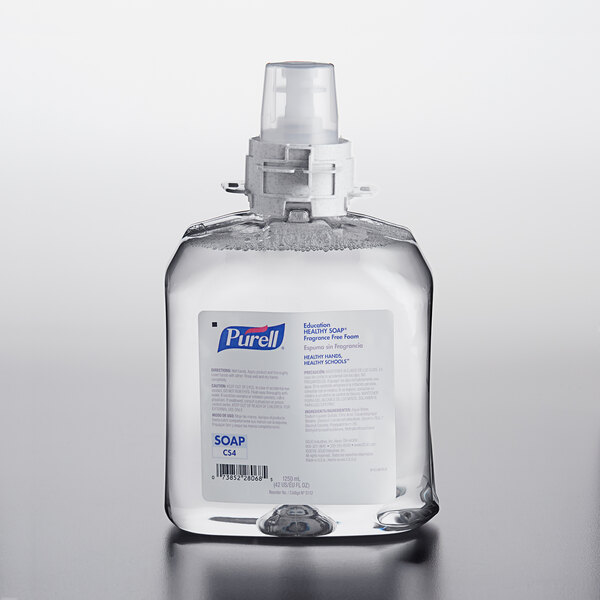 A clear plastic bottle of Purell Healthy Soap on a table. The white label reads "Purell Healthy Soap".