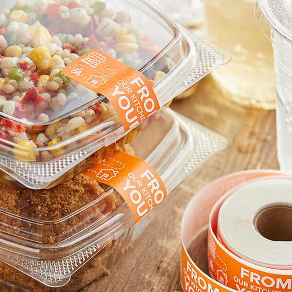 A plastic container of food with an orange TamperSafe paper label on it.