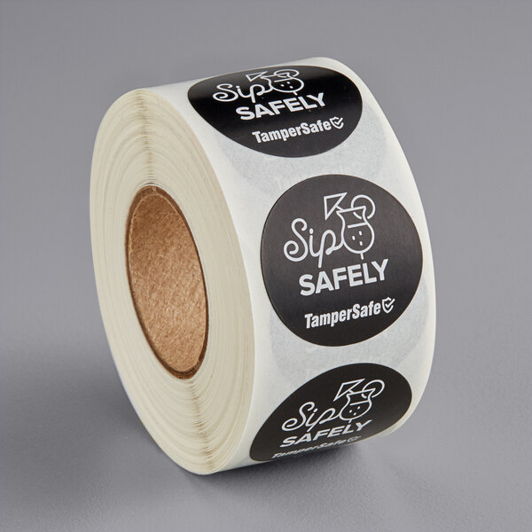A roll of TamperSafe black paper labels with white text.