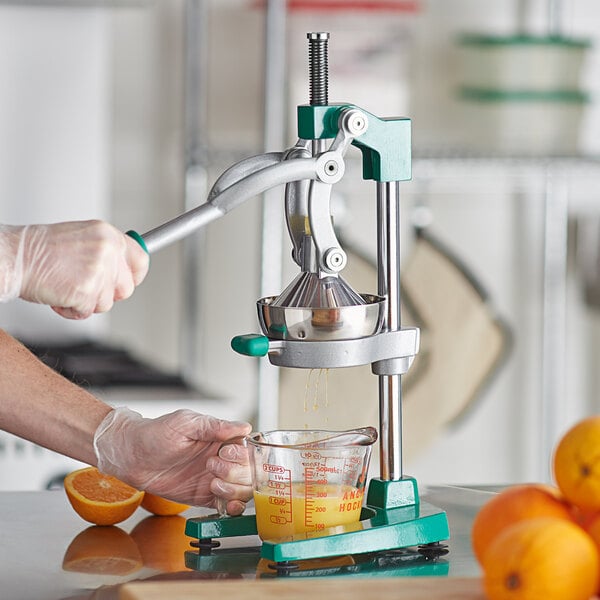 Chef juicing oranges with a manual hand press juicer