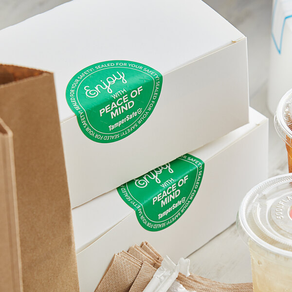 A stack of white boxes with green TamperSafe labels.