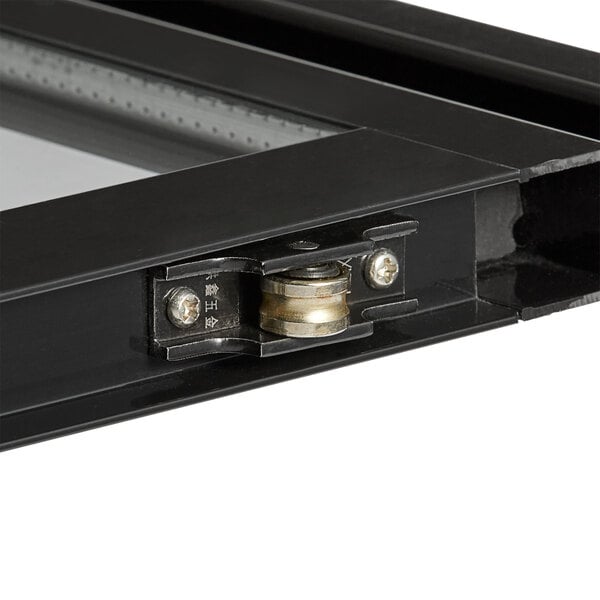 A close-up of a black metal sliding glass door with a metal latch.