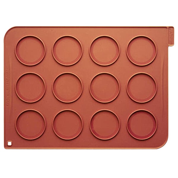 A red silicone baking tray with eight circles.