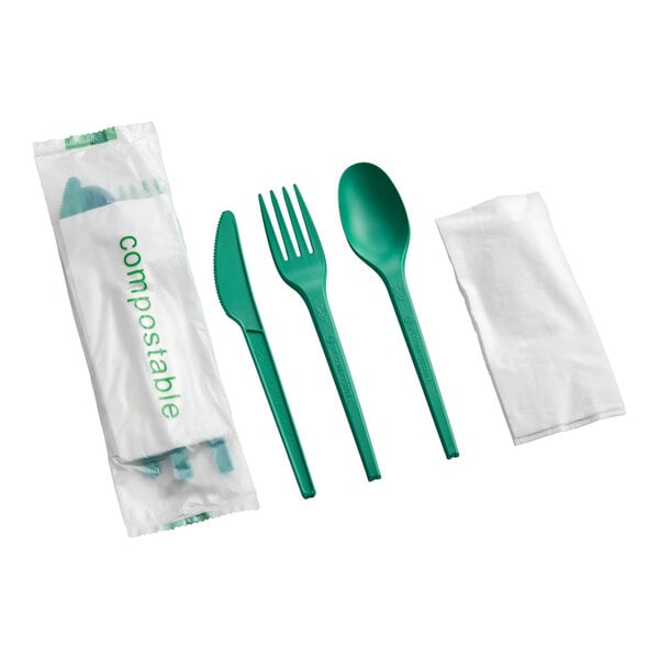 A set of green compostable cutlery including a knife, fork, spoon, and a napkin, individually wrapped.