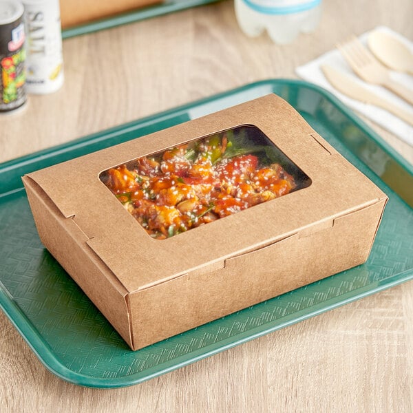 A Kraft folded paper take-out container with food inside on a tray.