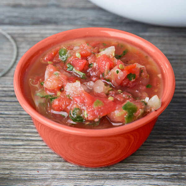 A Rio Orange melamine bouillon with salsa on a wood table.