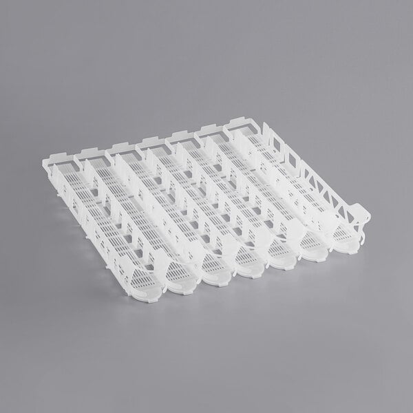 A white plastic Beverage-Air bottle organizer tray with holes for 32 oz. bottles.