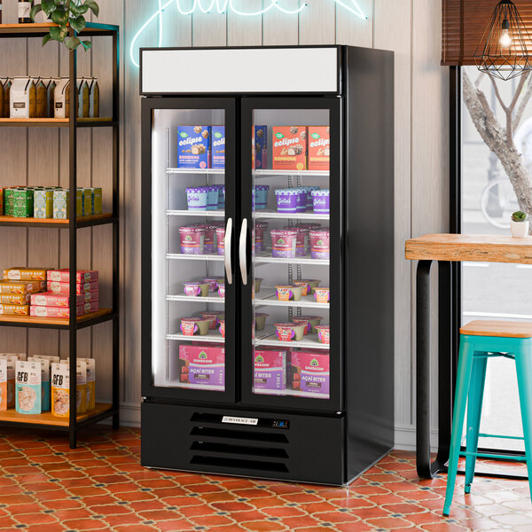 A black double-door merchandising freezer with a white interior, stocked with various frozen products.