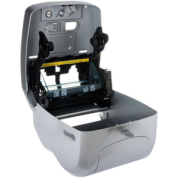 A stainless steel San Jamar paper towel dispenser with a yellow tape measure.