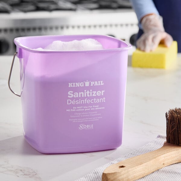 A purple Noble King-Pail 6 quart sanitizing pail filled with soapy water.