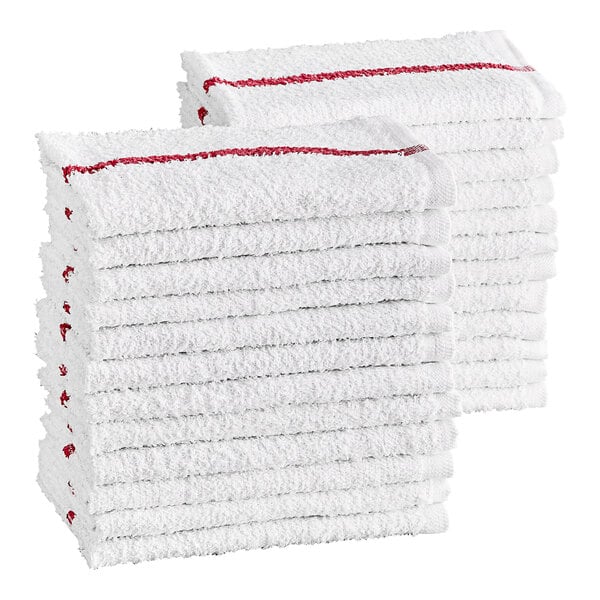 Two stacks of white cotton towels with a red stripe along the edge, neatly folded.