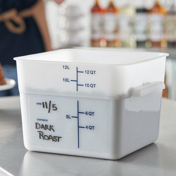 A close-up of a white Carlisle square food storage container with black writing.