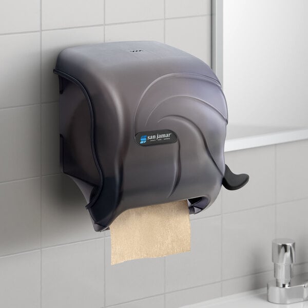 A black plastic San Jamar paper towel dispenser mounted on a wall.