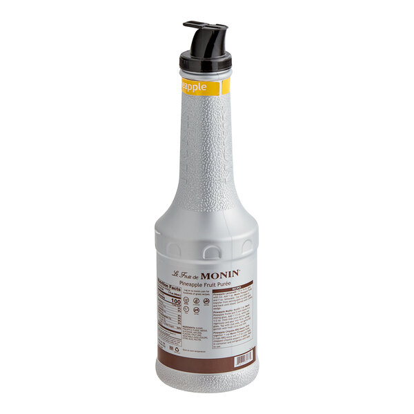 A close-up of a Monin Pineapple Fruit Puree bottle with a black lid.
