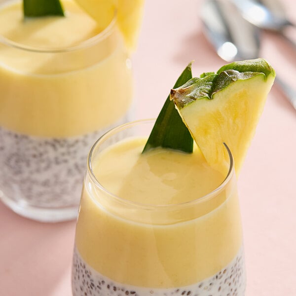 A close-up of a glass of yellow Monin Pineapple Fruit Puree
A close-up of a fruit on top of a glass of yellow liquid.