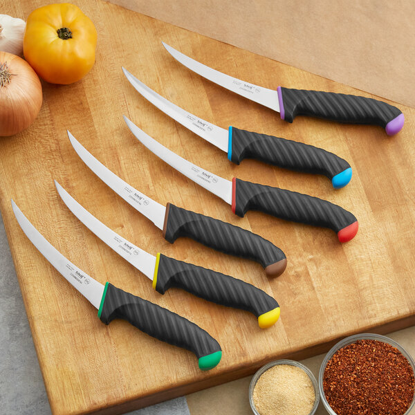 A Schraf yellow boning knife with black and red knives on a cutting board.