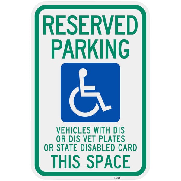 A green and blue aluminum parking lot sign that says "Handicapped Reserved Parking / Vehicles With Dis Or Dis Vet Plates" with a wheelchair symbol.