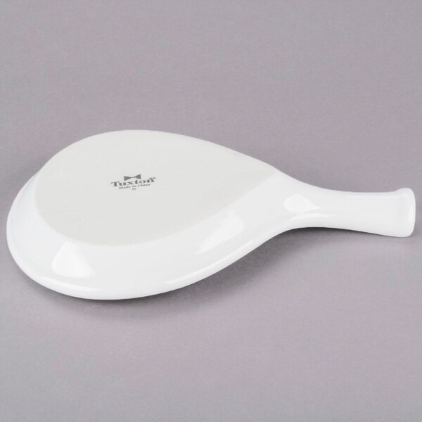 A Tuxton white china fry pan server with a handle.