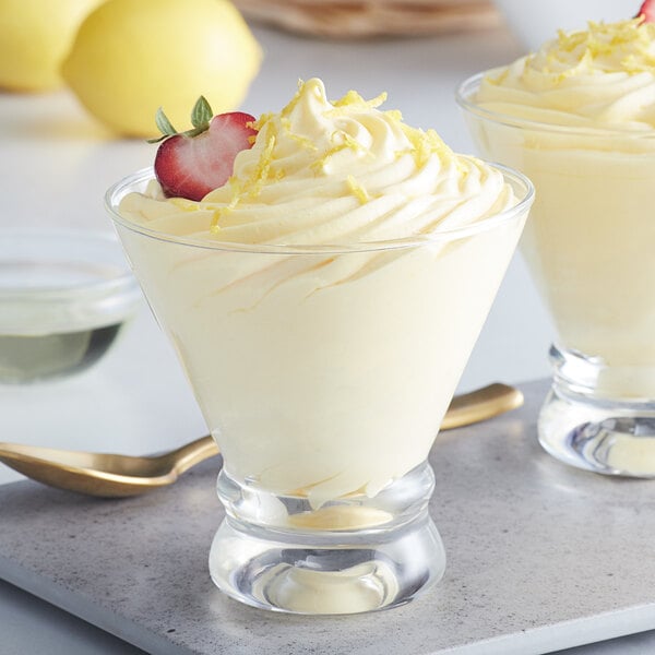 A dessert in a glass with whipped cream and a strawberry on top.