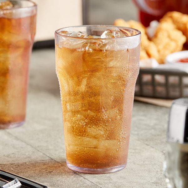 Two Choice clear plastic tumblers filled with iced tea on a table.