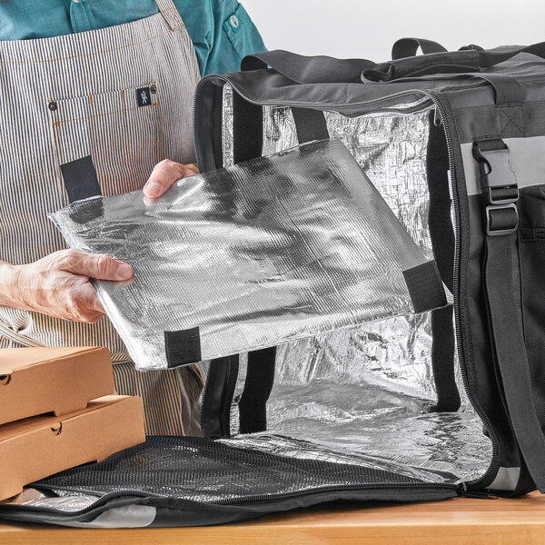 A man using a ServIt large square backpack delivery bag to hold a pizza box.