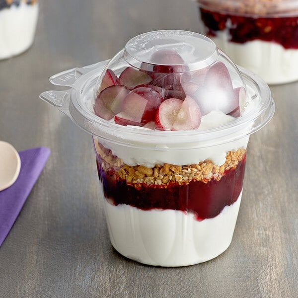 A Dart SafeSeal plastic snack cup filled with food and covered with a dome lid.