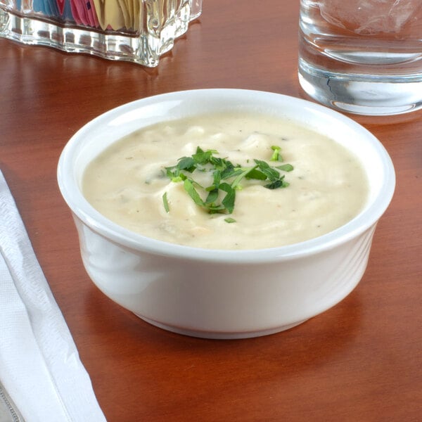 a bowl of soup with green garnish on top