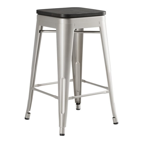 A Lancaster Table & Seating backless metal counter height stool with a black wood seat.