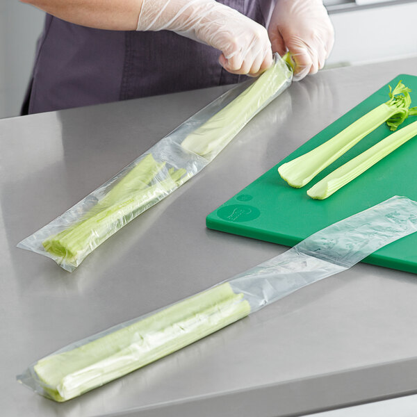 A person holding celery in a Choice clear polyethylene layflat bag.