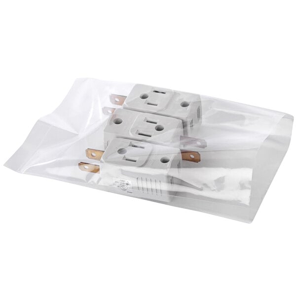 A clear plastic TamperSafe bag with perforated tear strips over three white plastic bags with electrical plugs inside.