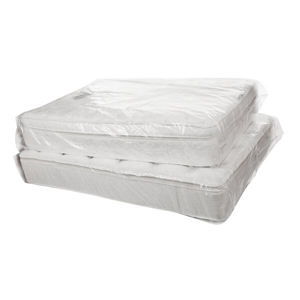 A stack of mattresses wrapped in a Lavex polyethylene mattress bag.