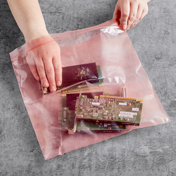 A person holding a Lavex pink anti-static bag with a group of electronic components.