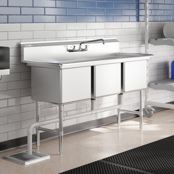 A Regency stainless steel 3 compartment commercial sink with legs and cross bracing.