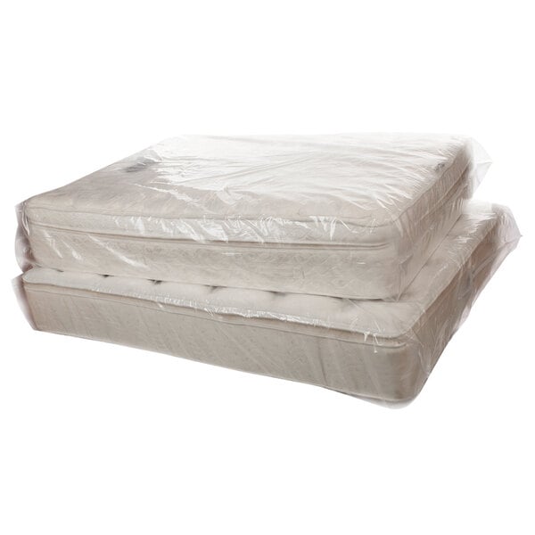 Two Lavex plastic bags covering a stack of mattresses.