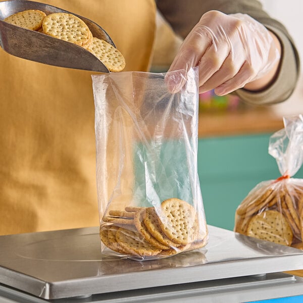 A person putting cookies into a Choice clear plastic bag.